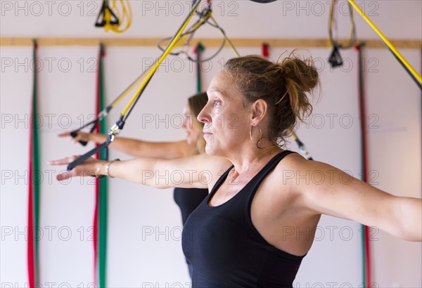 Caucasian women using resistance bands in gymnasium