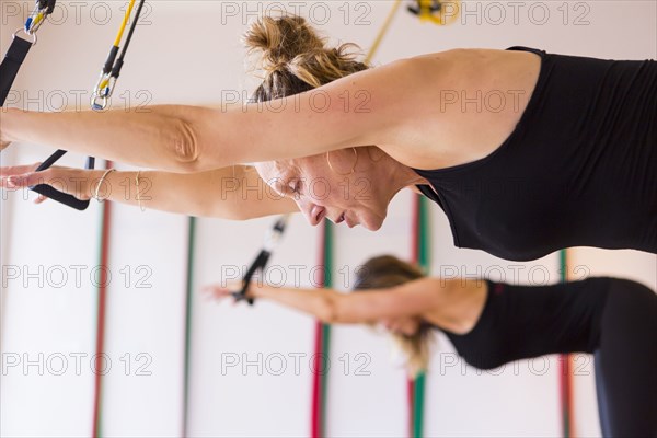Caucasian women using resistance bands in gymnasium