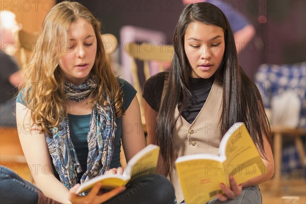 Teenage girls reading scripts in theater class