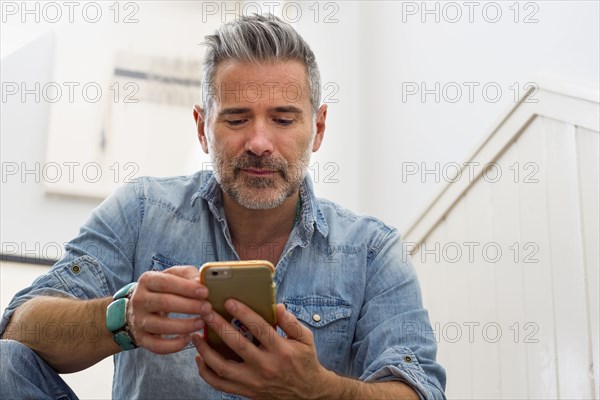 Caucasian man texting on cell phone