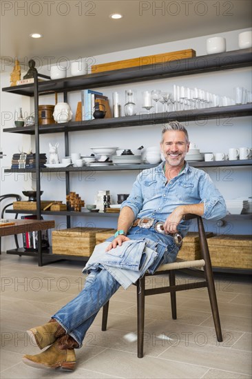 Smiling Caucasian man relaxing on chair in store