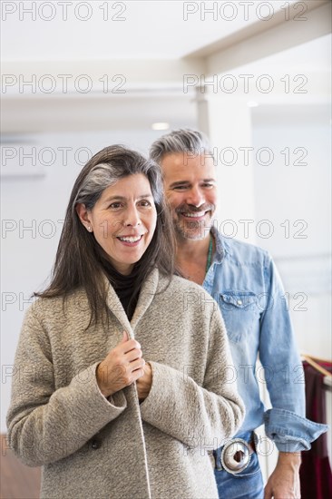 Man watching woman examining coat in store