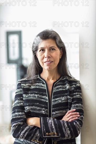 Portrait of Hispanic woman leaning on wall