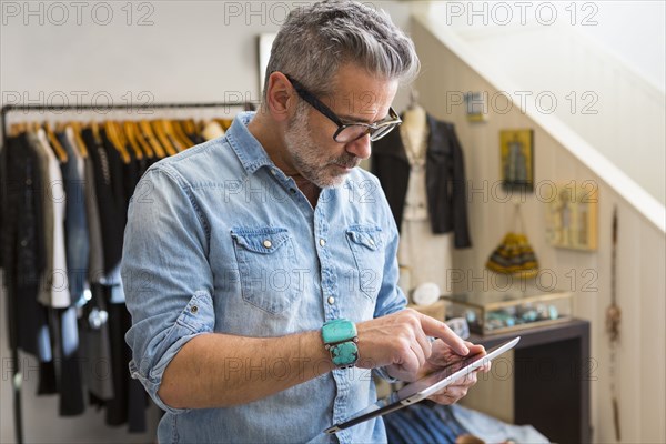Caucasian man using digital tablet in store