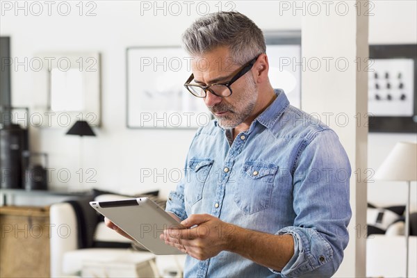 Caucasian man using digital tablet in livingroom