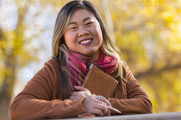 Portrait of smiling Asian woman in autumn