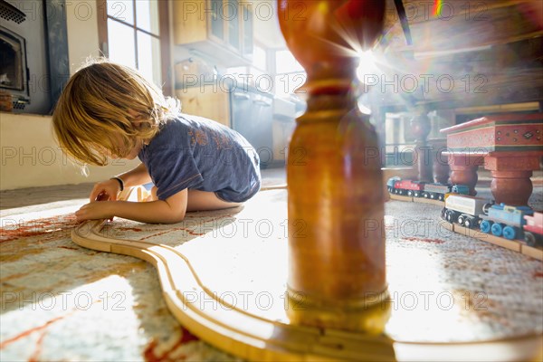 Caucasian boy playing with toy race track on floor