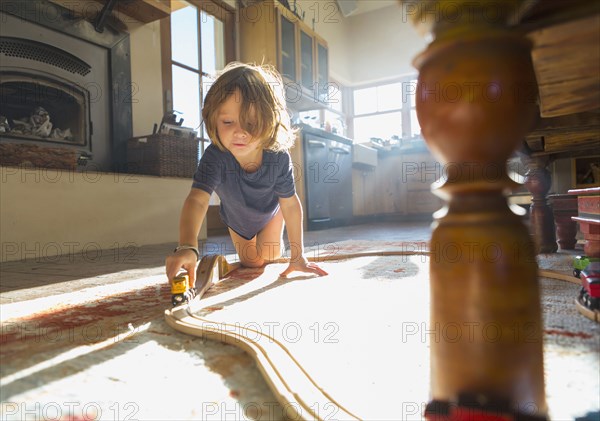 Caucasian boy playing with toy race track on floor