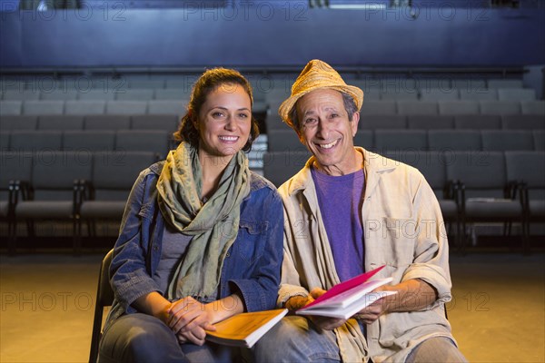 Portrait of Caucasian actors with scripts in theater
