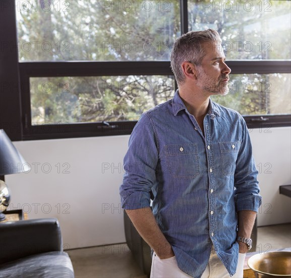 Portrait of pensive Caucasian man in livingroom