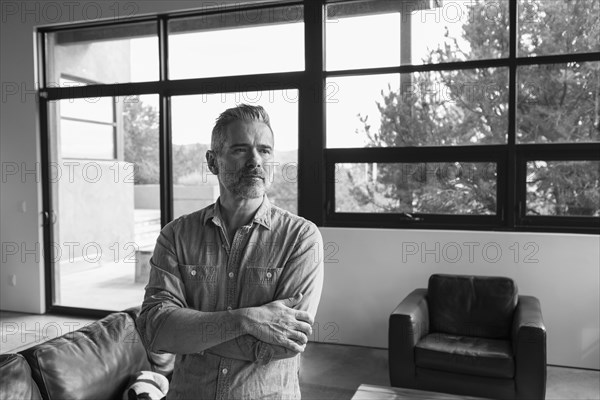 Portrait of pensive Caucasian man in livingroom