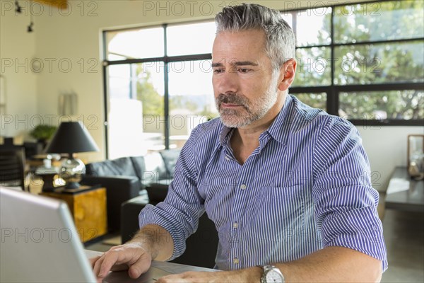 Caucasian man using laptop on table