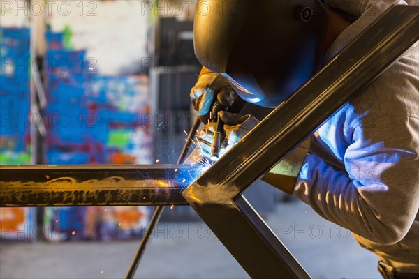 Man welding metal sculpture