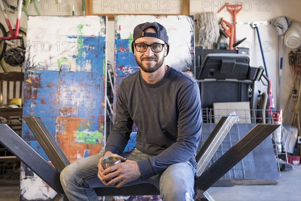 Portrait of Caucasian man sitting on metal sculpture