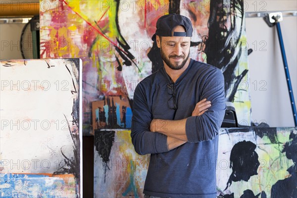 Pensive Caucasian man standing near paintings