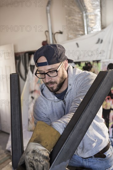 Caucasian man examining metal sculpture