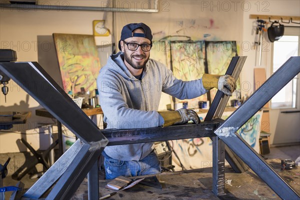 Portrait of Caucasian man leaning on metal sculpture