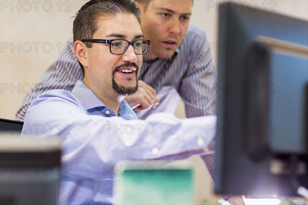 Businessmen talking near computer in office