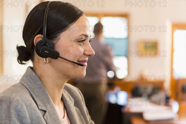 Profile of smiling Caucasian businesswoman wearing headset