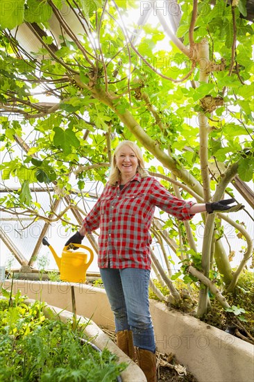 Caucasian woman posing in greenhouse