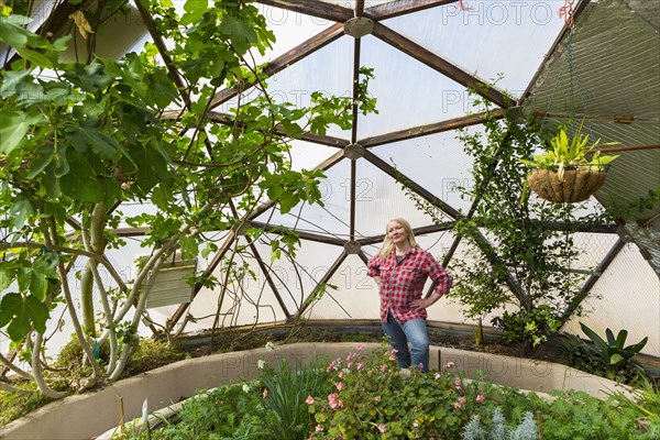 Caucasian woman posing in greenhouse