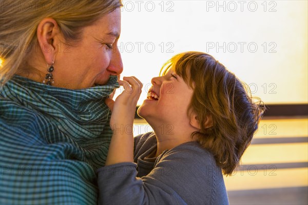 Caucasian mother watching son play with her collar