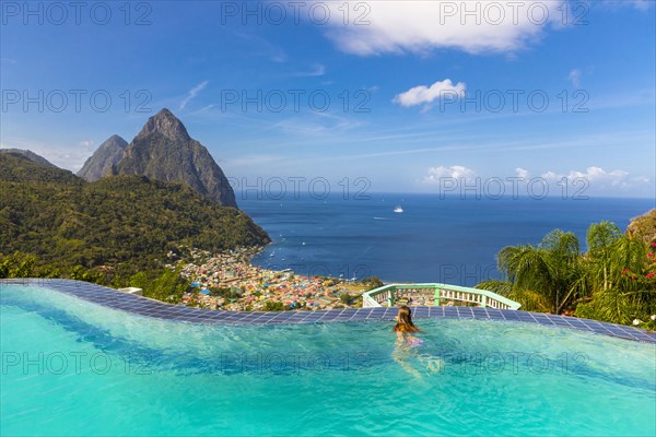 Caucasian girl swimming in infinity pool