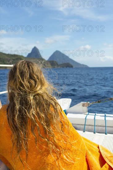 Caucasian girl sitting on boat wrapped in a towel