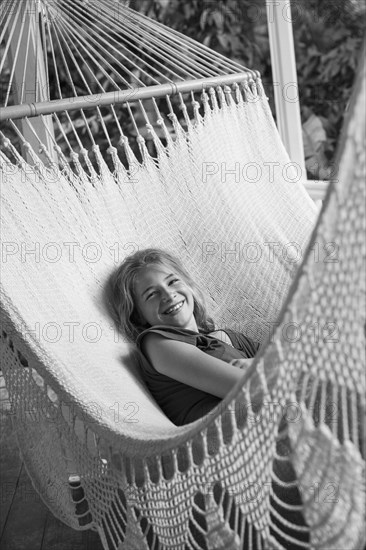 Smiling Caucasian girl laying in hammock