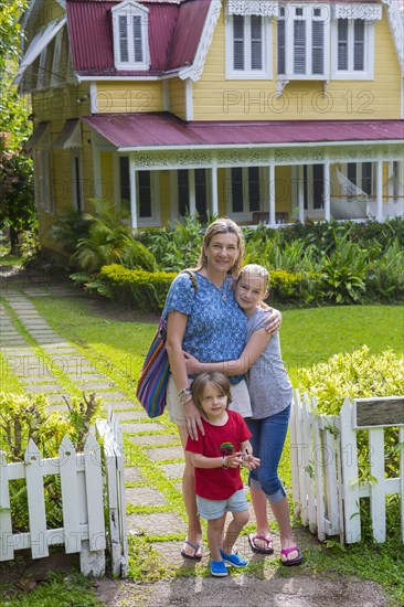 Caucasian mother with son and daughter in front view house