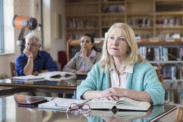 Curious older woman listening in library