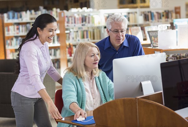 Older man and women using computer in library