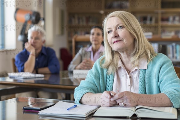 Curious older woman listening in library