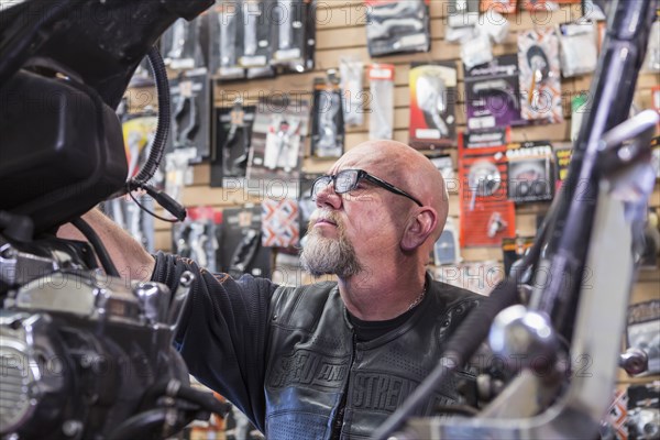 Caucasian man repairing motorcycle