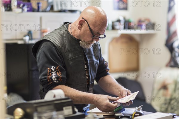 Caucasian man reading paperwork on clipboard