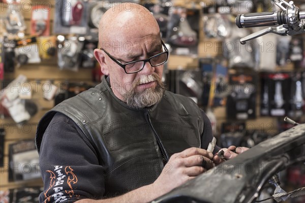 Caucasian man repairing motorcycle