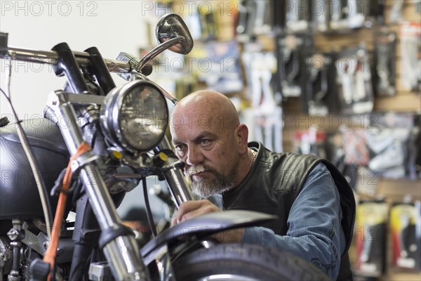 Caucasian man repairing motorcycle