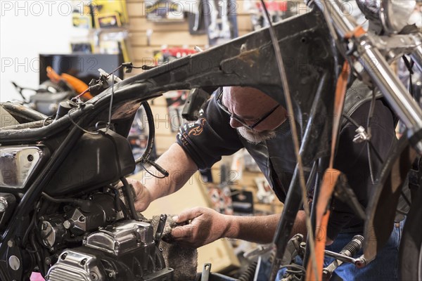 Caucasian man repairing motorcycle