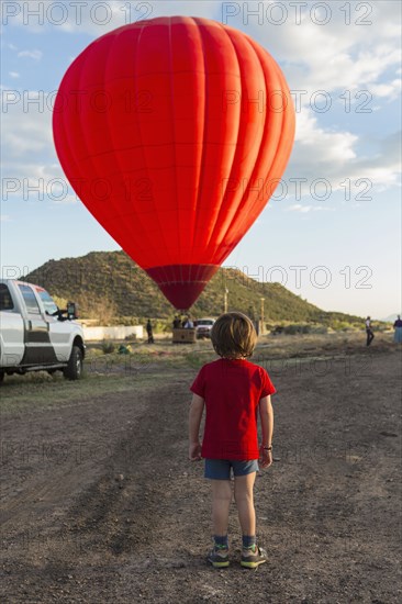 Caucasian boy watching distant hot air balloon