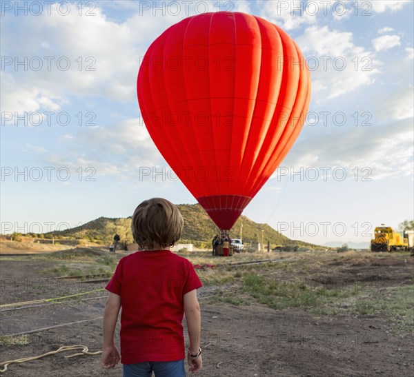 Caucasian boy watching distant hot air balloon