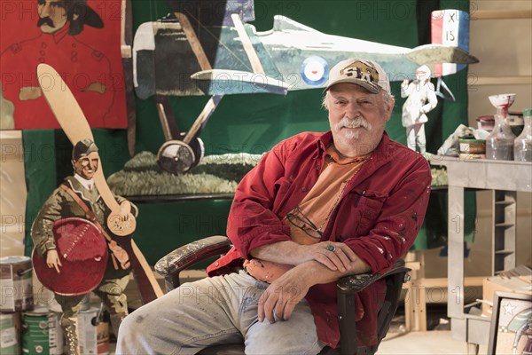 Portrait of older Caucasian man sitting in workshop