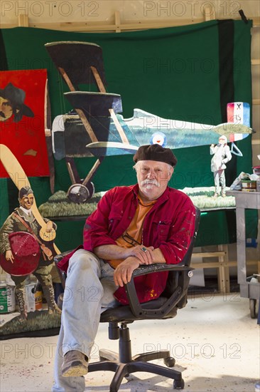 Portrait of older Caucasian man sitting in workshop