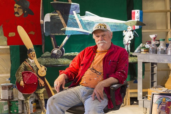 Portrait of older Caucasian man sitting in workshop