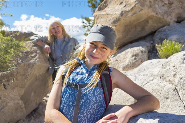 Portrait of Caucasian girl and grandmother hiking near rocks