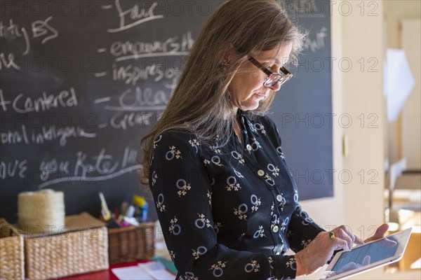 Caucasian teacher using digital tablet in classroom