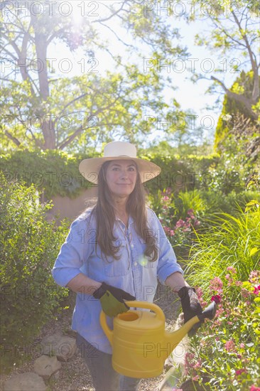 Older Caucasian woman holding watering can