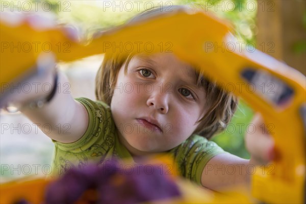 Caucasian boy playing with construction toilet