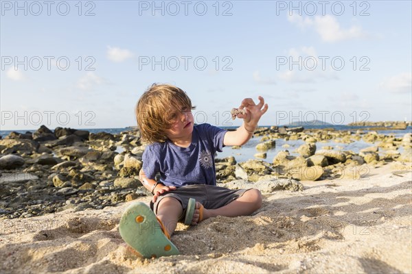 Caucasian boy playing in sand at beach