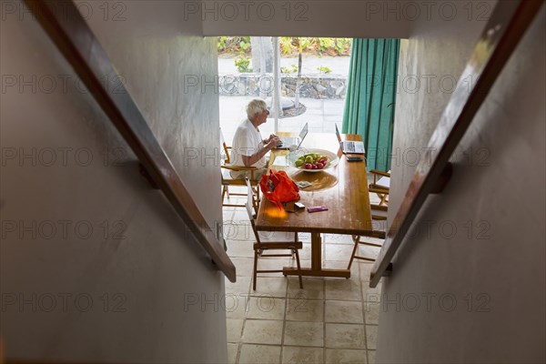 Caucasian man using laptop near staircase