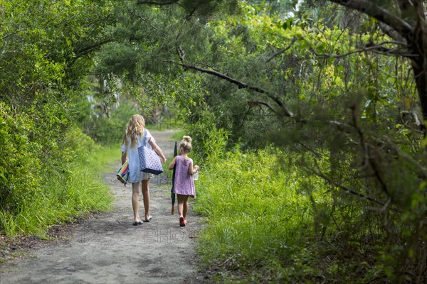 Caucasian sisters walking on dirt path